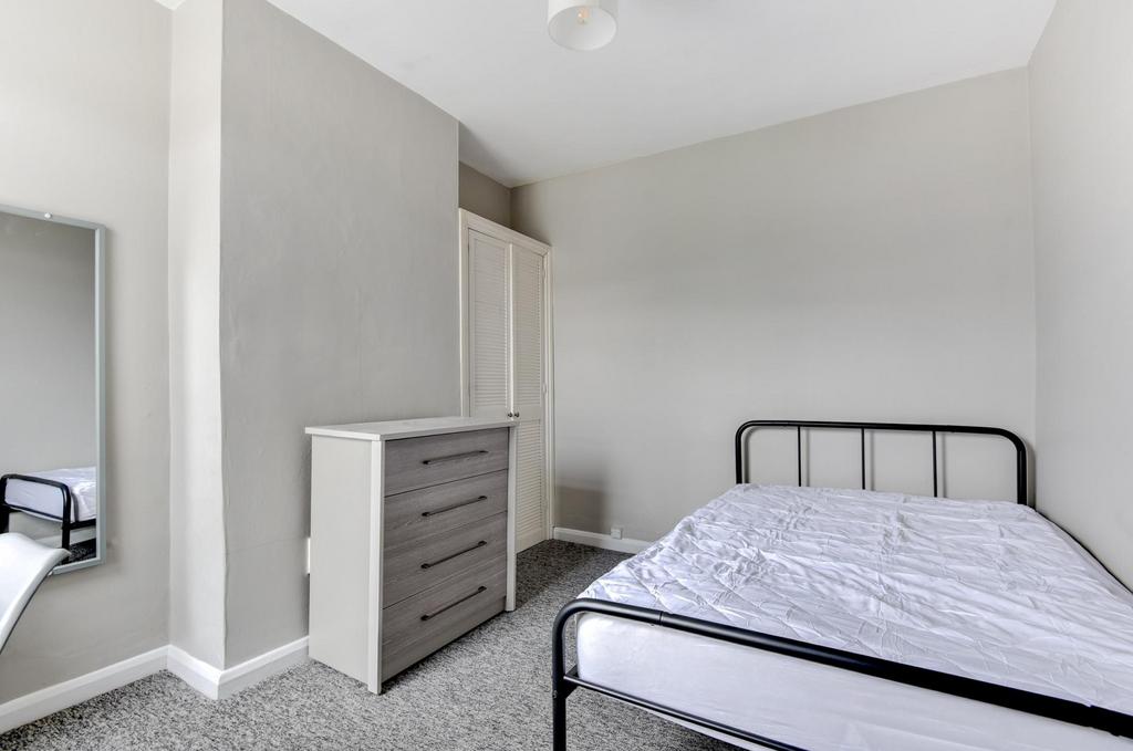 Bright, neatly presented bedroom with a metal d...