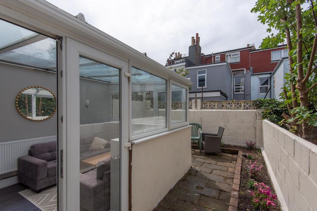 Private paved rear garden with a sheltered seat...