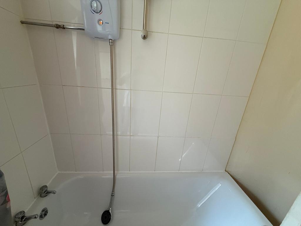 Bright, tiled bathroom with a built-in bathtub ...
