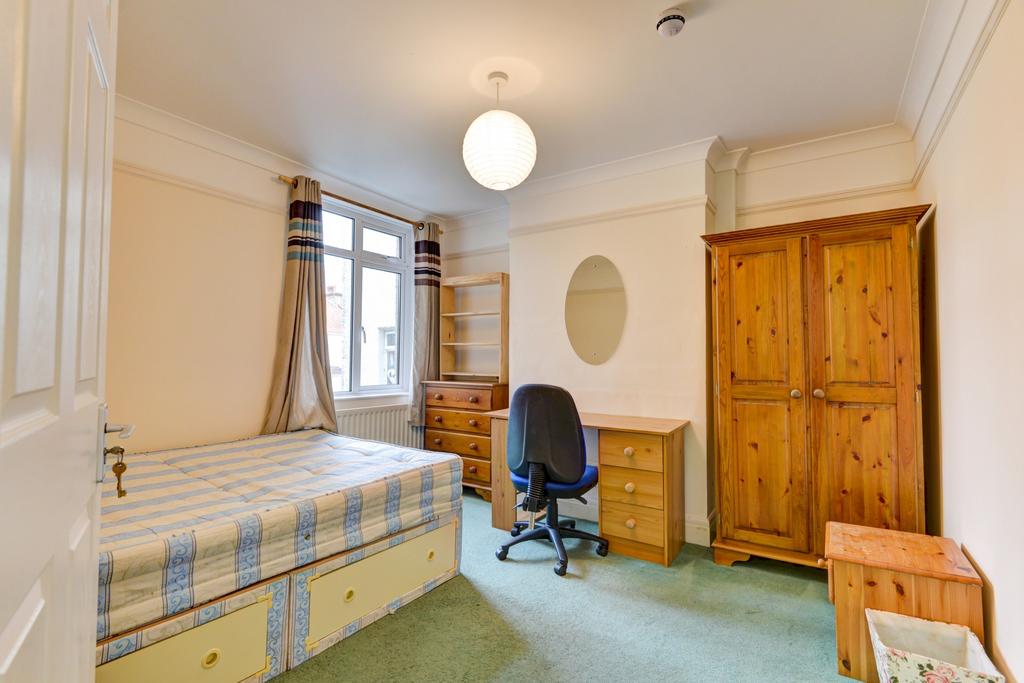 A well-lit, spacious master bedroom featuring a...