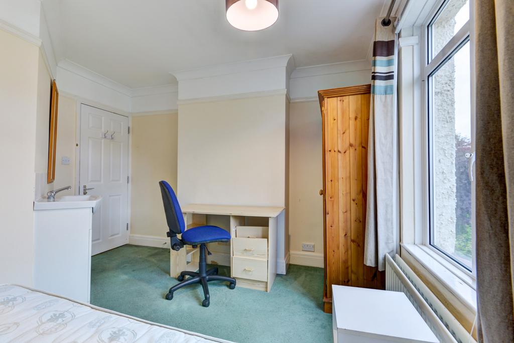 Bright single bedroom with a large window letti...