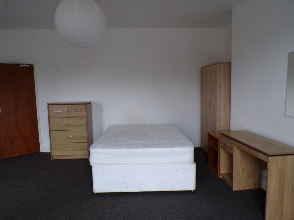 Bright, simply furnished double bedroom with a ...