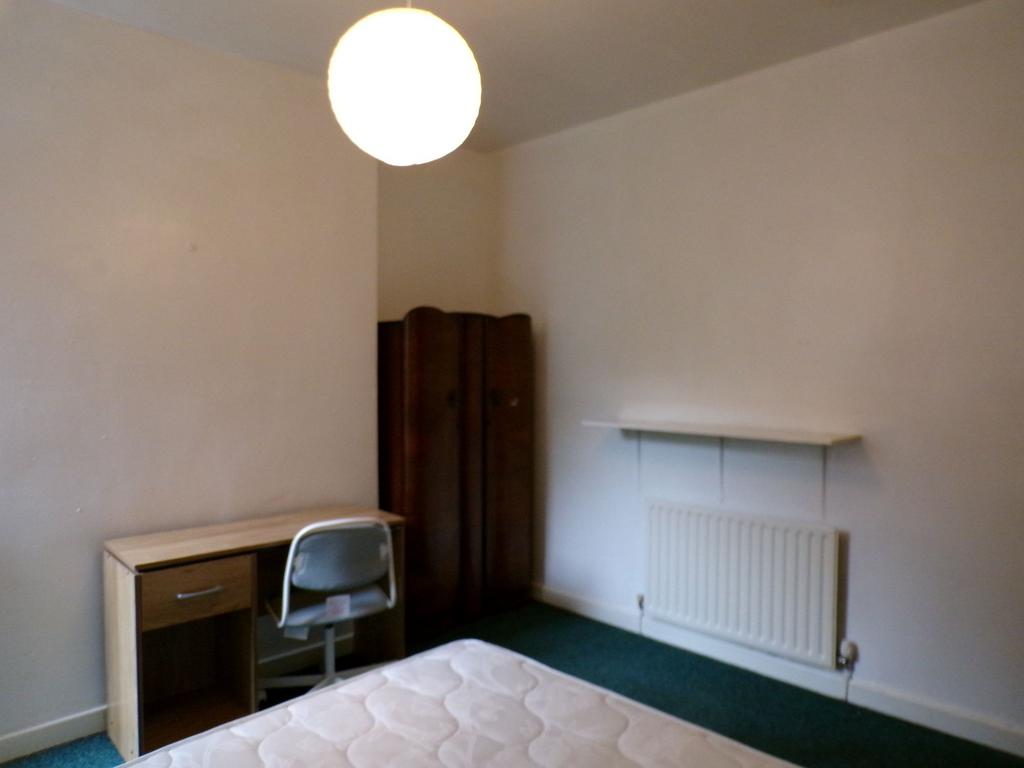 Simple, neutrally painted bedroom with a mattre...