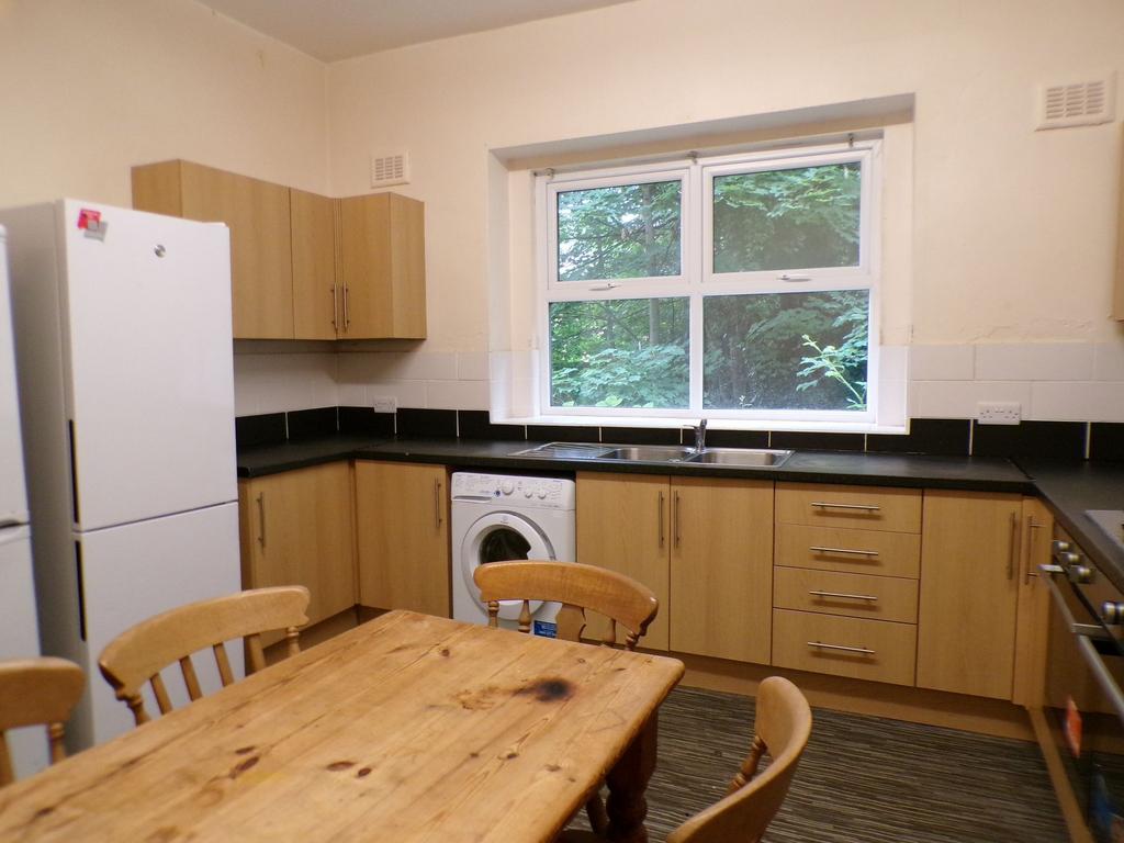 Bright kitchen with light wood cabinets, black ...