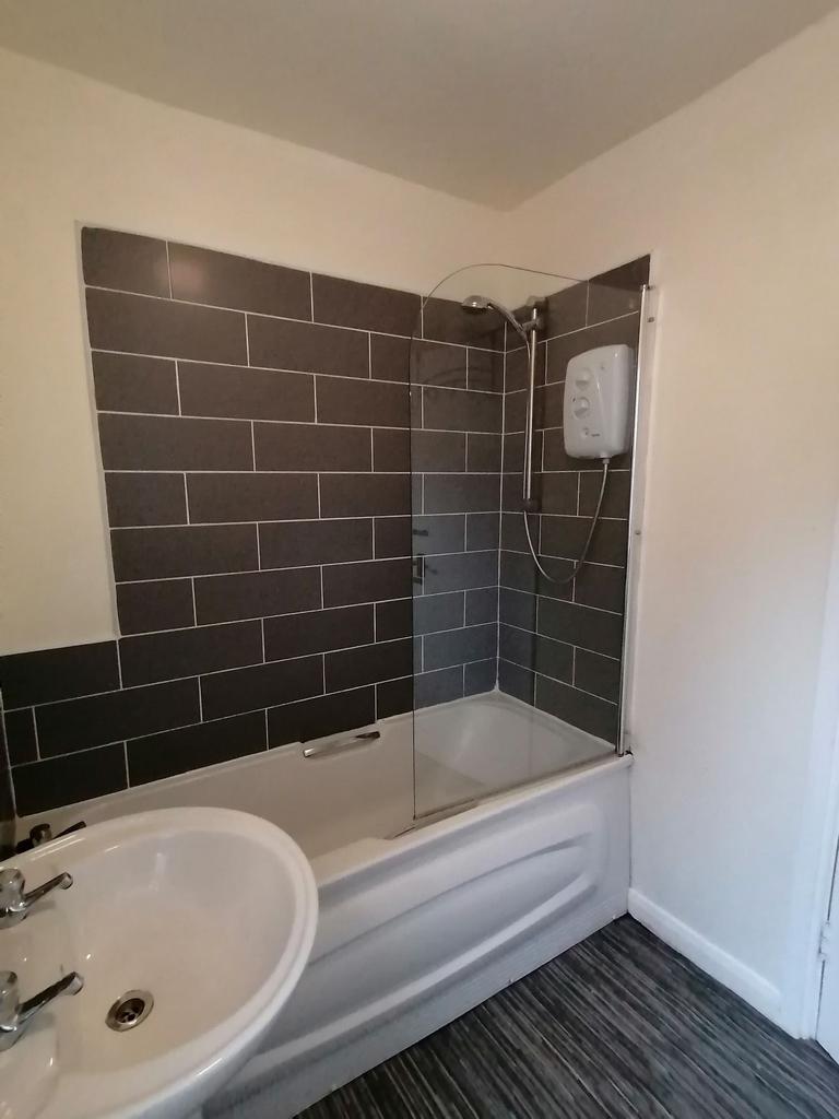 Bright, modern bathroom with a fitted shower-ov...