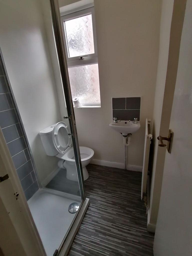 Compact bathroom with a tiled shower enclosure,...