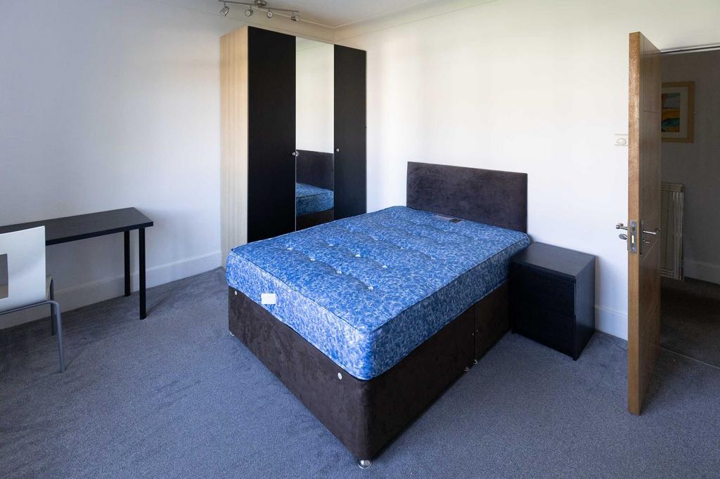 A clean and bright bedroom featuring a comforta...