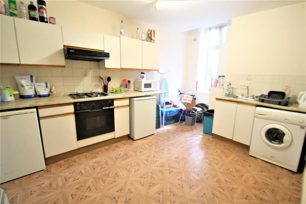 A spacious kitchen featuring white cabinets, a ...