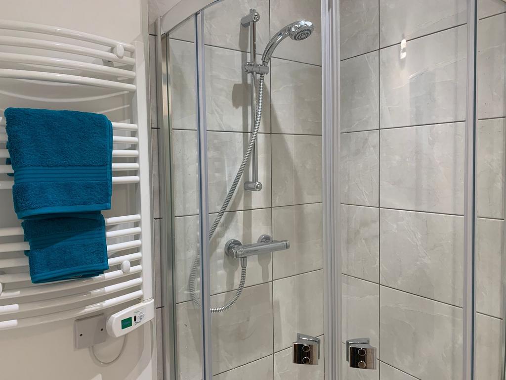 Modern tiled bathroom with a glass-enclosed sho...