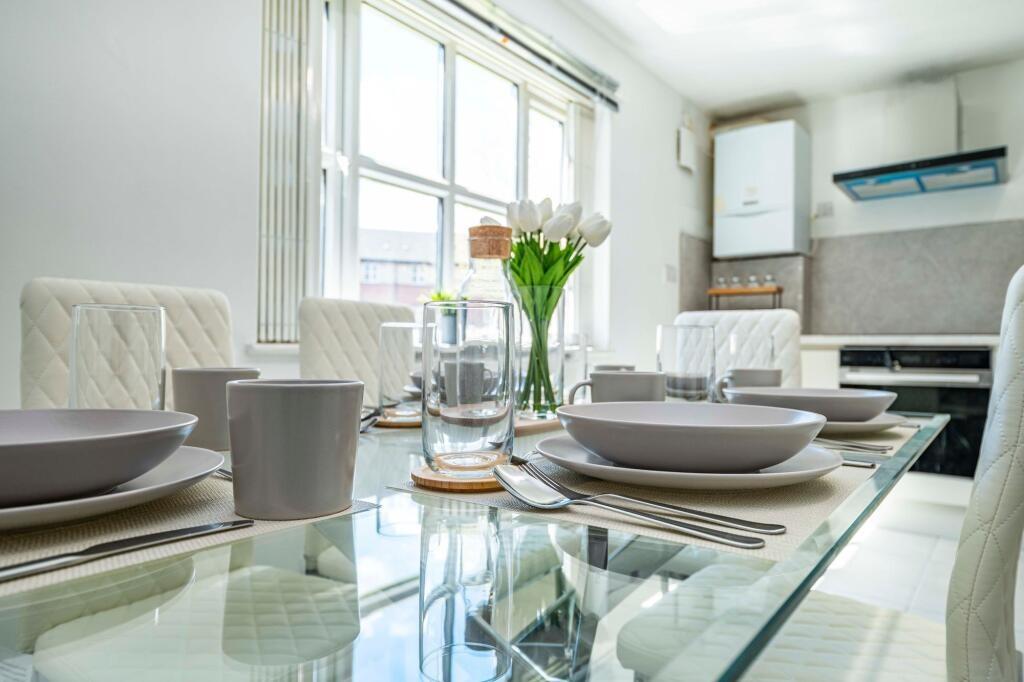 Bright, modern kitchen-dining area with a glass...