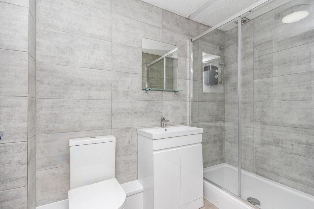 Modern tiled bathroom with a walk-in shower enc...