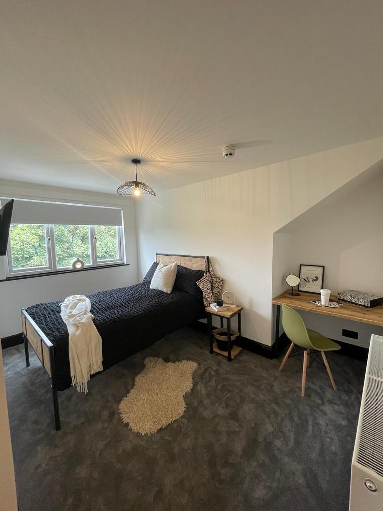 A spacious and well-lit bedroom featuring a lar...