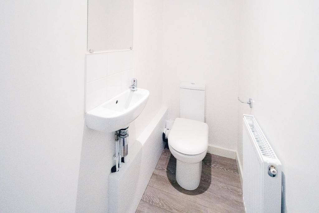 Bright, modern WC with clean white fixtures, a ...
