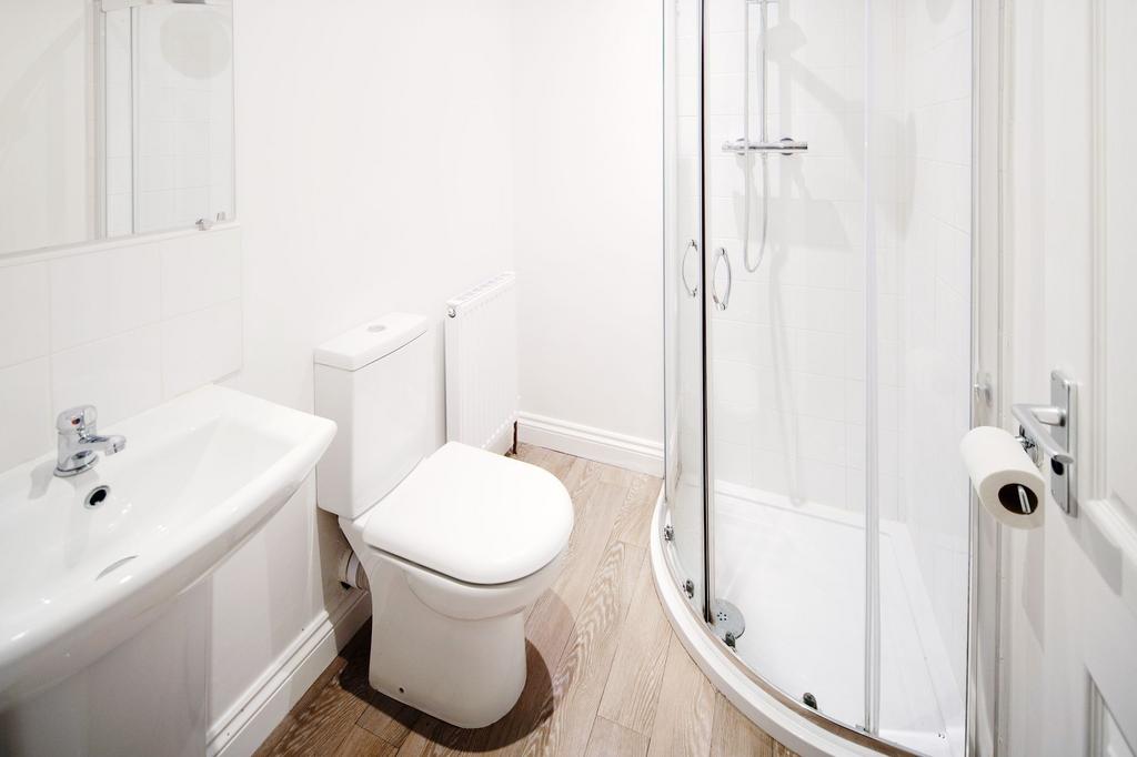 Bright, modern bathroom with a curved glass sho...