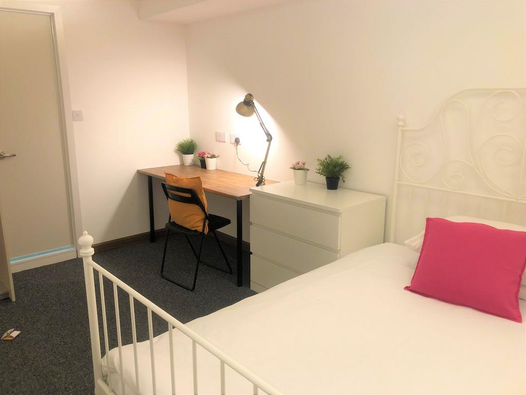 A bright and tidy single bedroom featuring a wh...