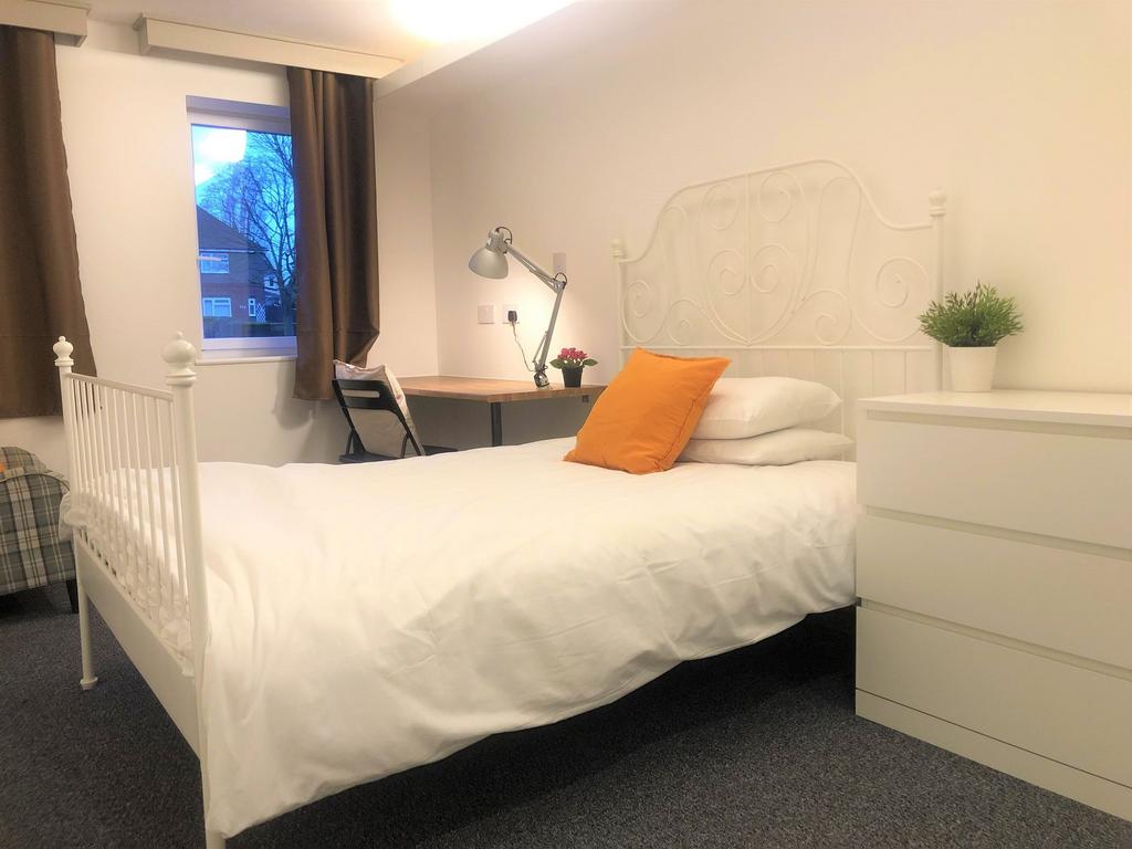 Bright and cozy single bedroom featuring a cris...
