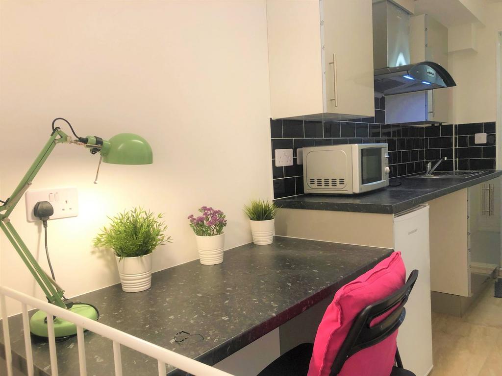 A compact and tidy kitchen area featuring a sle...