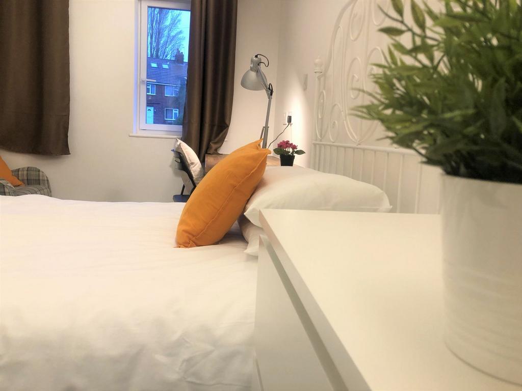 A cozy and neatly arranged double bedroom featu...