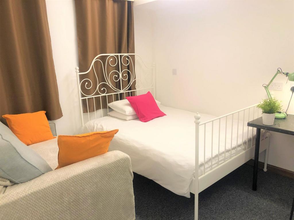 A cozy single bedroom featuring a decorative wh...