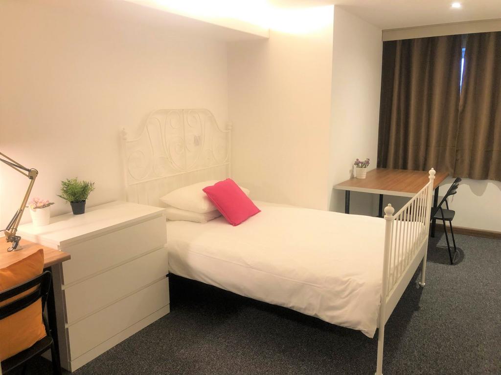 Bright and tidy single bedroom featuring a whit...