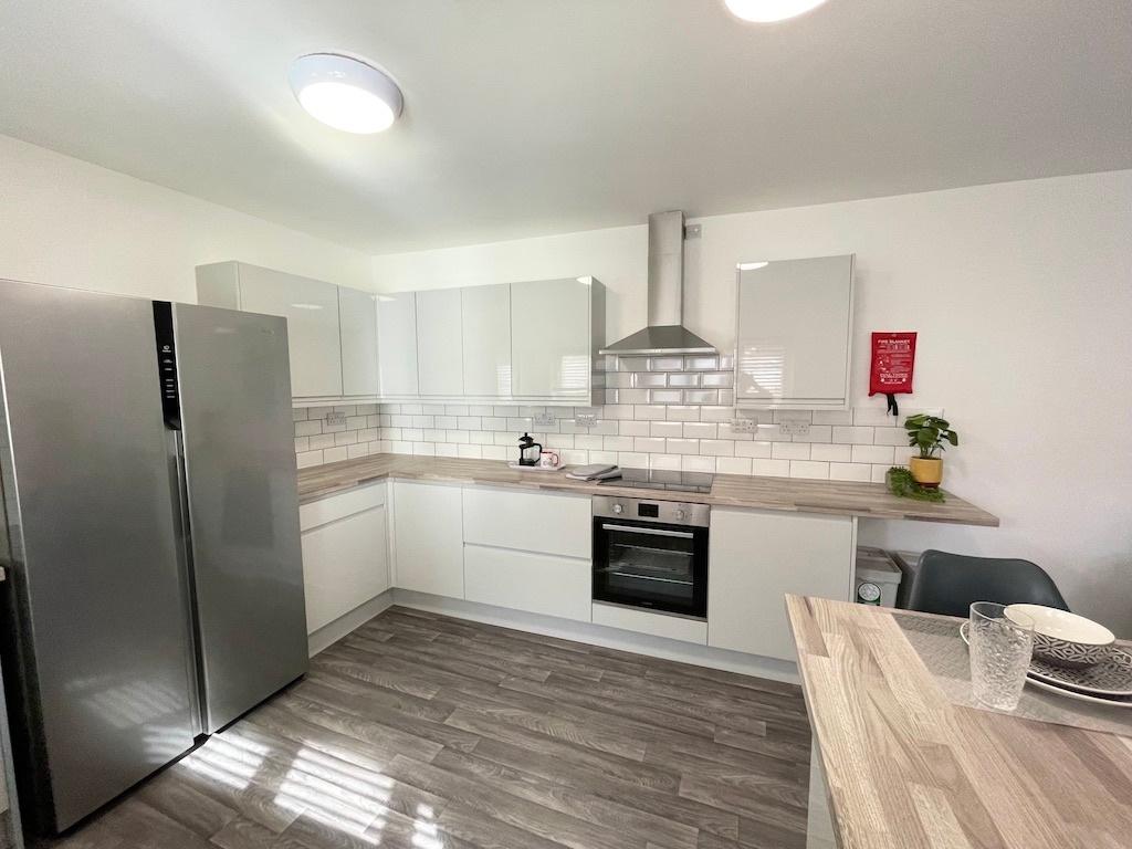 Bright modern kitchen with white gloss cabinets...