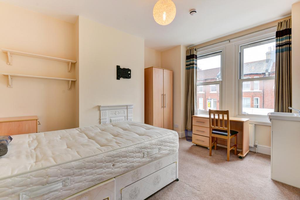 A bright and inviting student bedroom with a we...