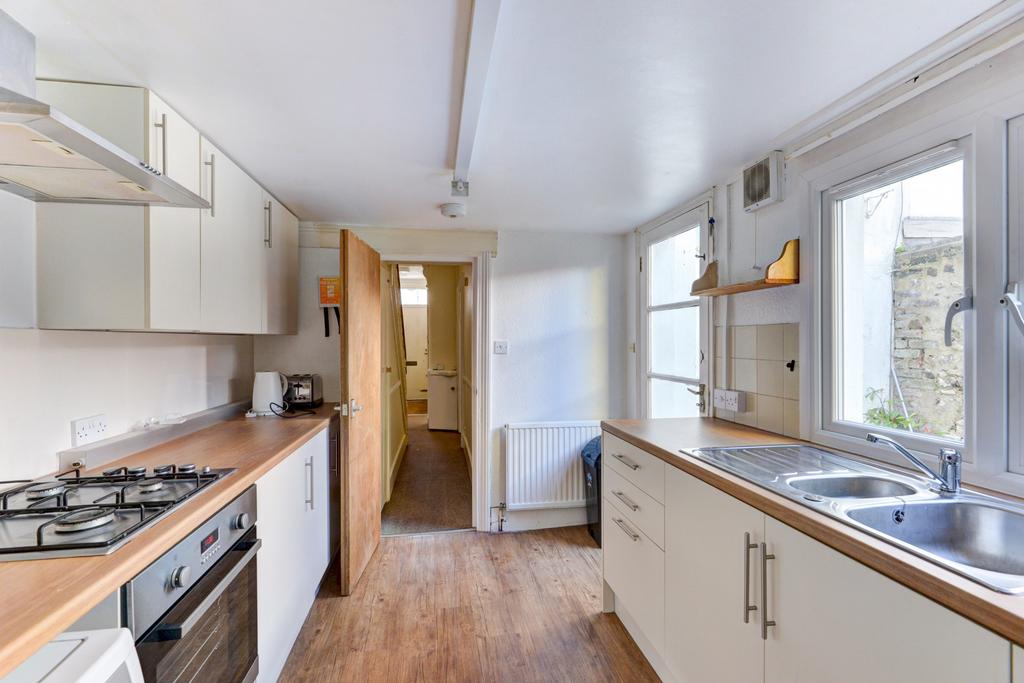 Bright, modern galley kitchen with integrated o...