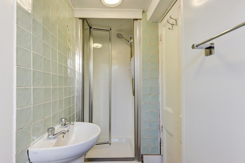 Neat bathroom with a tiled shower cubicle, pede...
