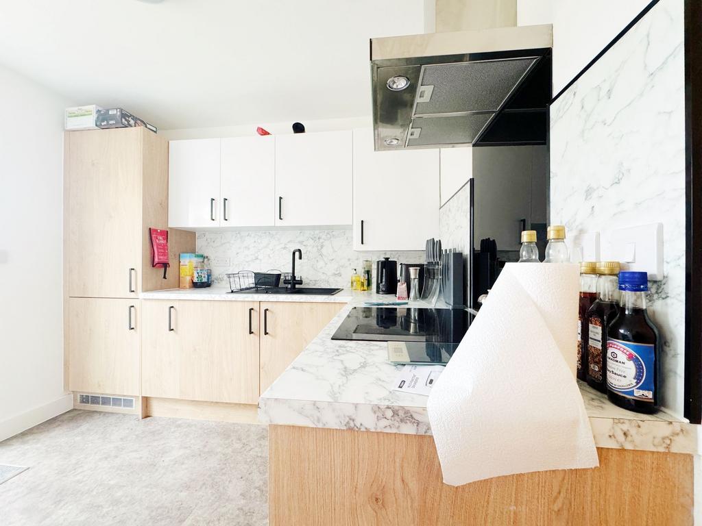 Bright modern kitchen with light wood cabinets,...