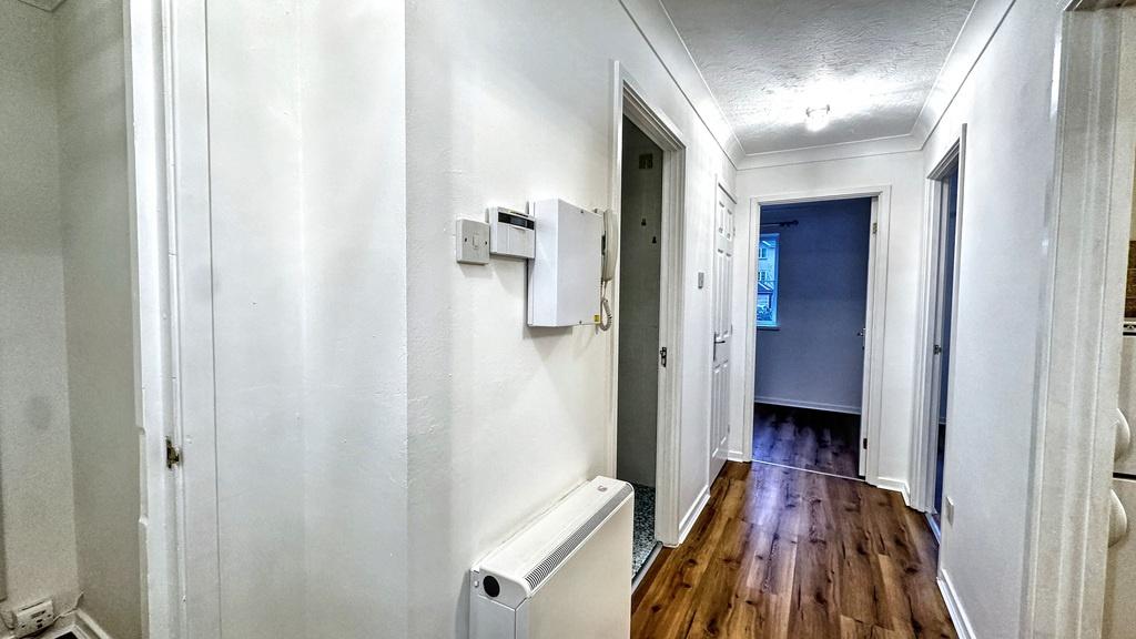 Bright, well-maintained hallway with fresh whit...