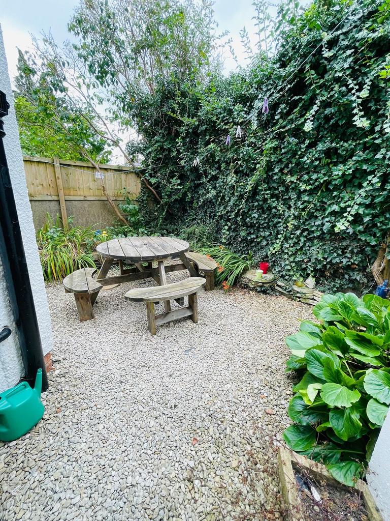 Secluded gravel garden with a rustic round wood...