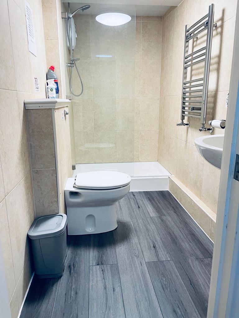 Modern tiled bathroom with a walk-in shower, wa...