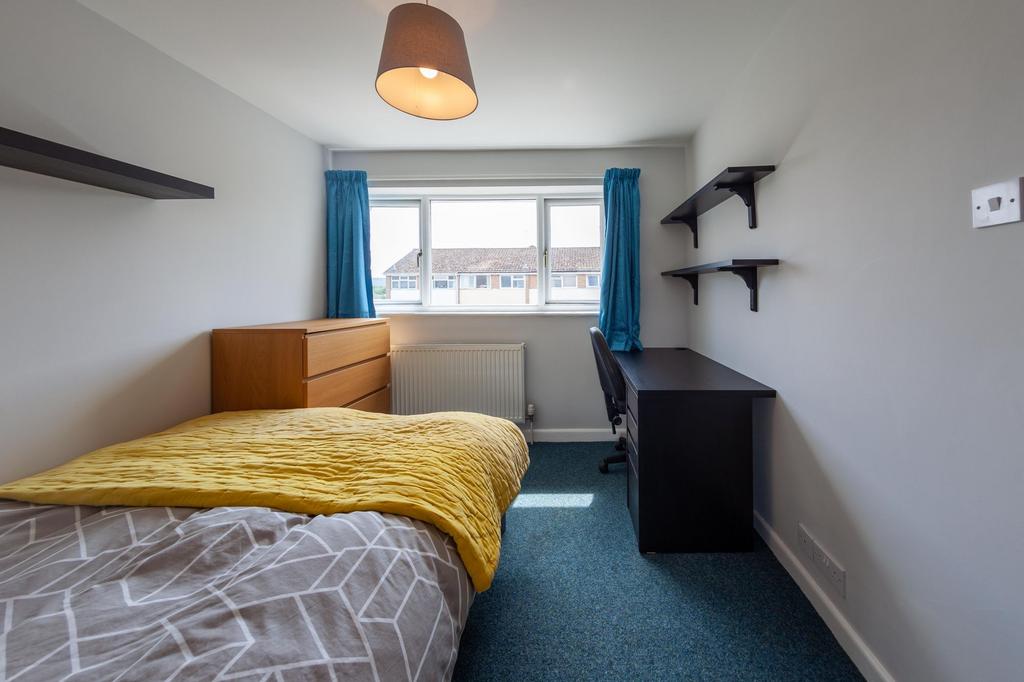 Bright, neatly furnished single bedroom with a ...