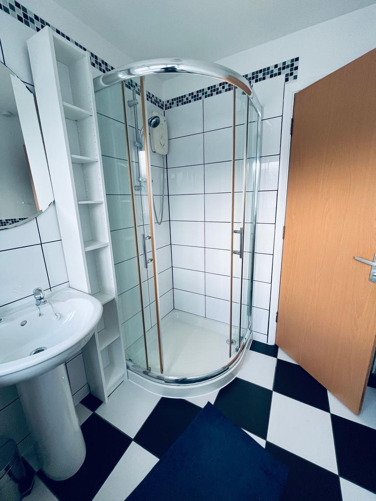 Bright, modern bathroom with a curved glass sho...