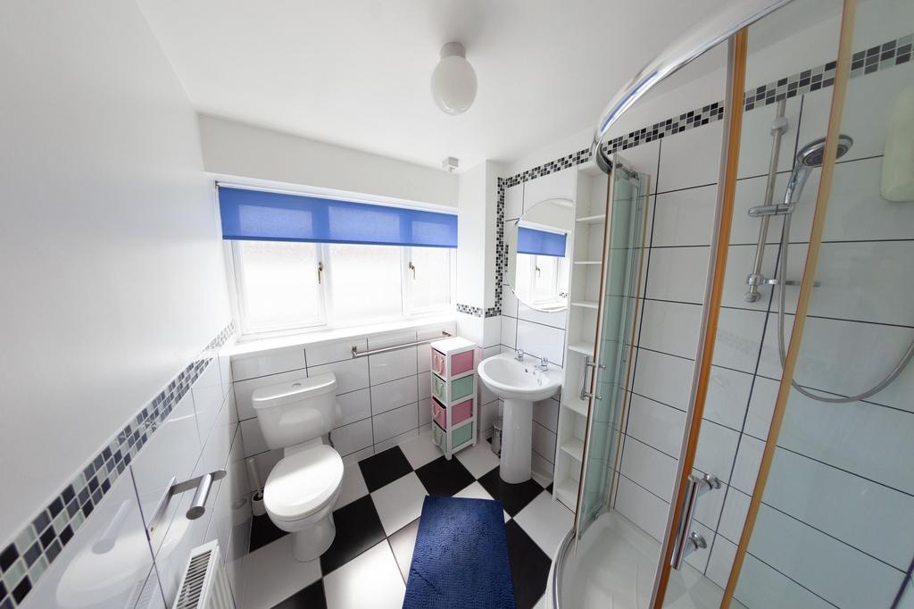 Bright, modern bathroom with a corner glass sho...