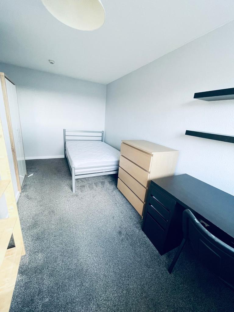 Bright, simply furnished bedroom with a single ...