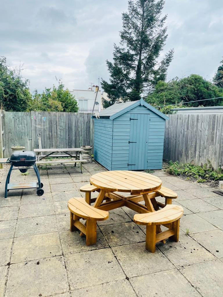 Paved private rear courtyard with a round woode...