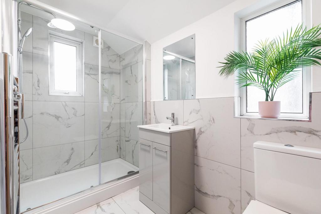 Bright, modern bathroom with a walk-in glass sh...