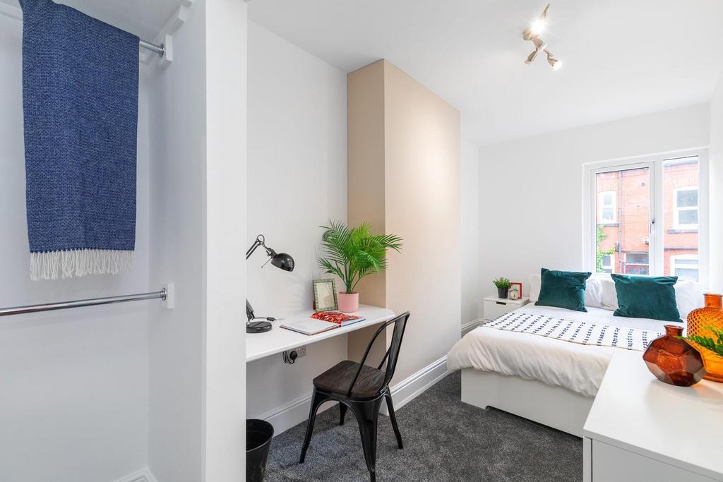 Bright, neatly styled double bedroom with a com...