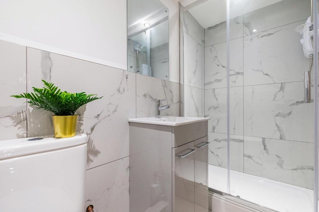 Bright, modern bathroom with full-length glass ...