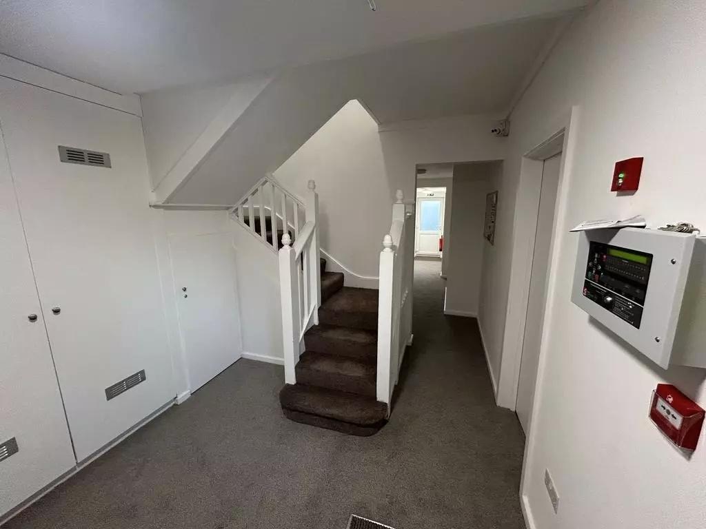 Bright communal stairwell and hallway with carp...