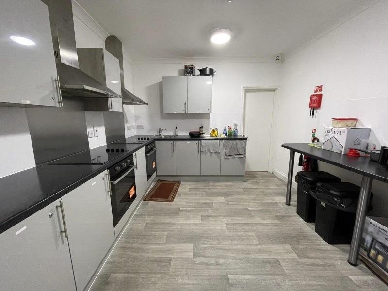 Modern fitted kitchen with sleek grey cabinets,...