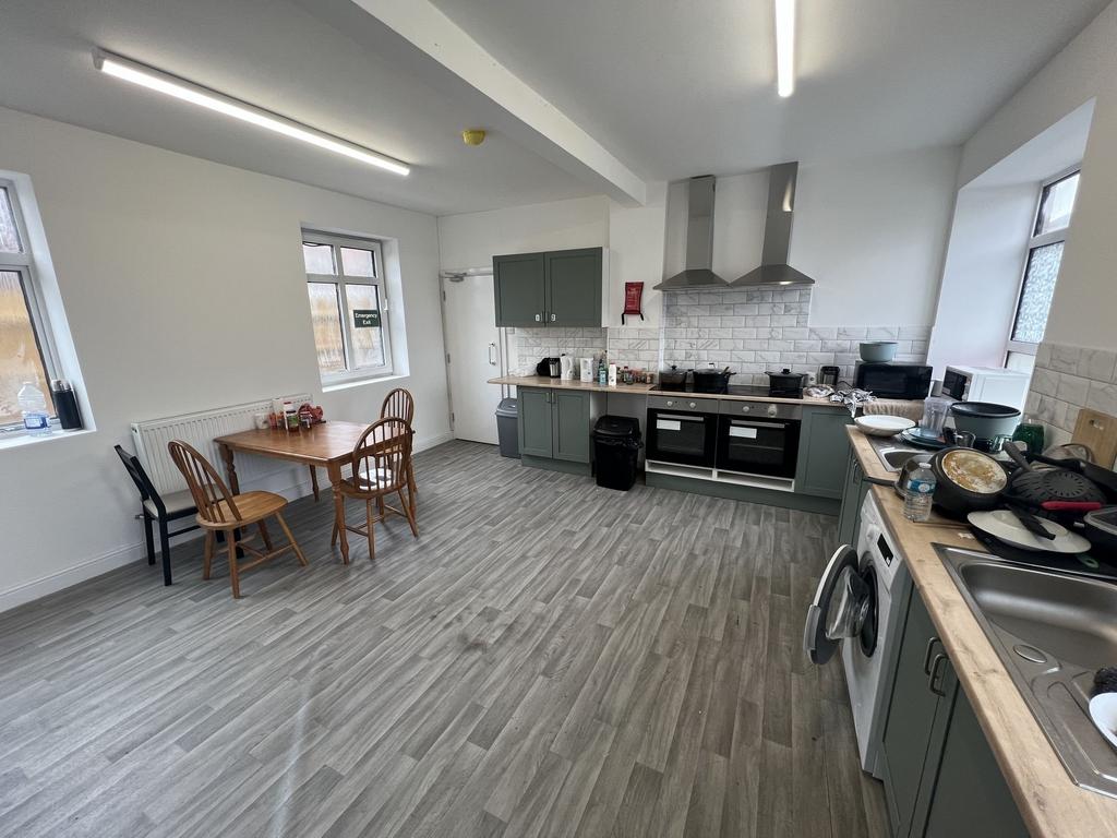 Bright communal kitchen with two large ovens, p...