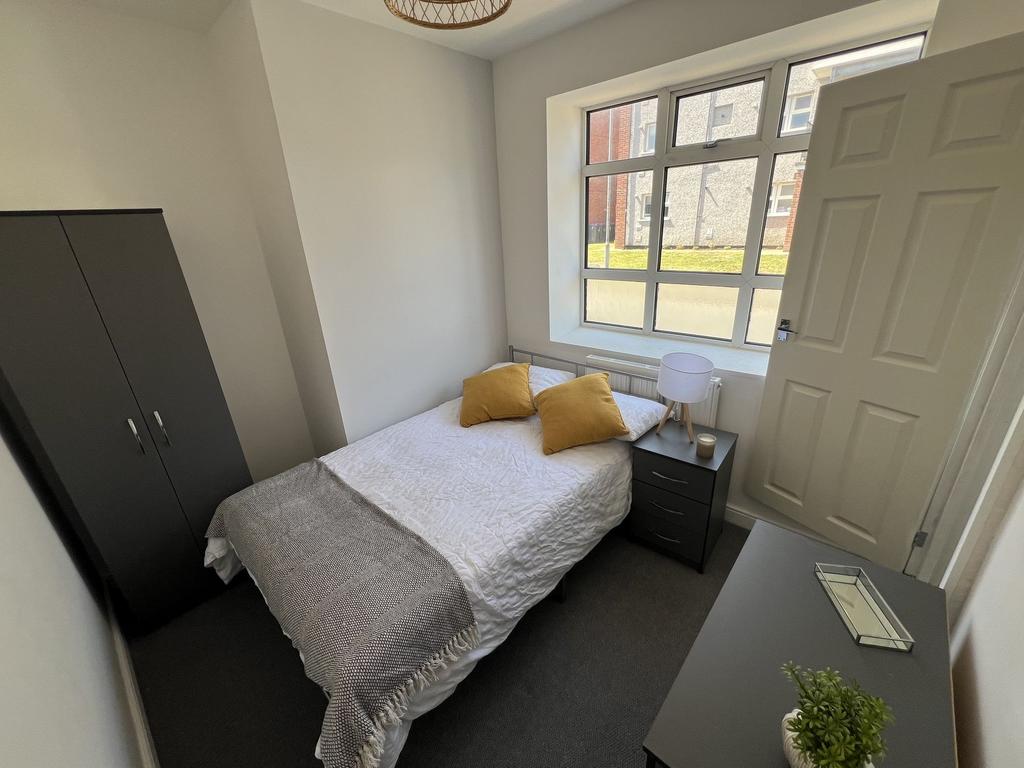 Bright, neatly furnished double bedroom with a ...