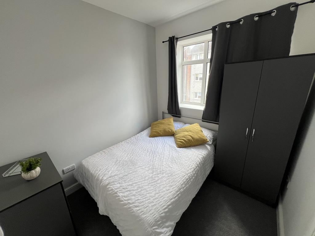 Bright, neatly presented bedroom featuring a do...