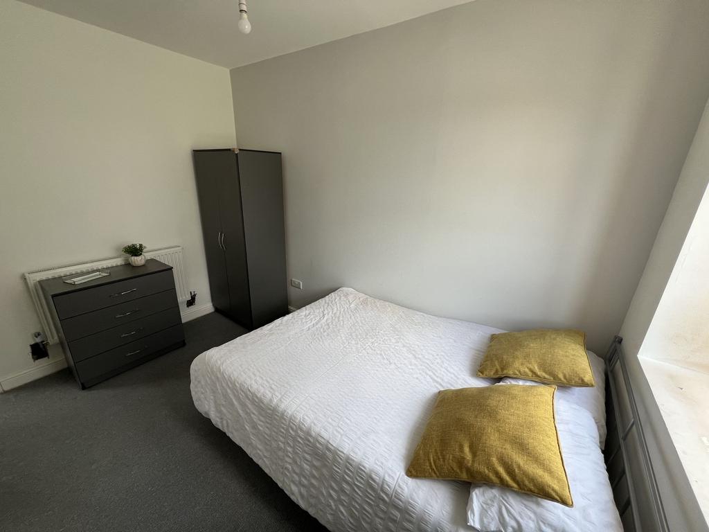 Bright, simply furnished double bedroom with a ...