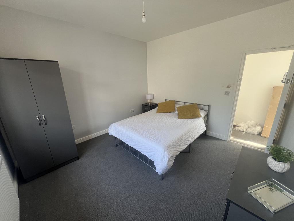 Bright, simply furnished double bedroom with a ...