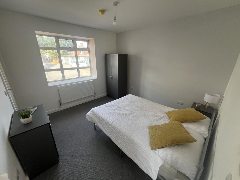 Bright, simply styled double bedroom with a lar...