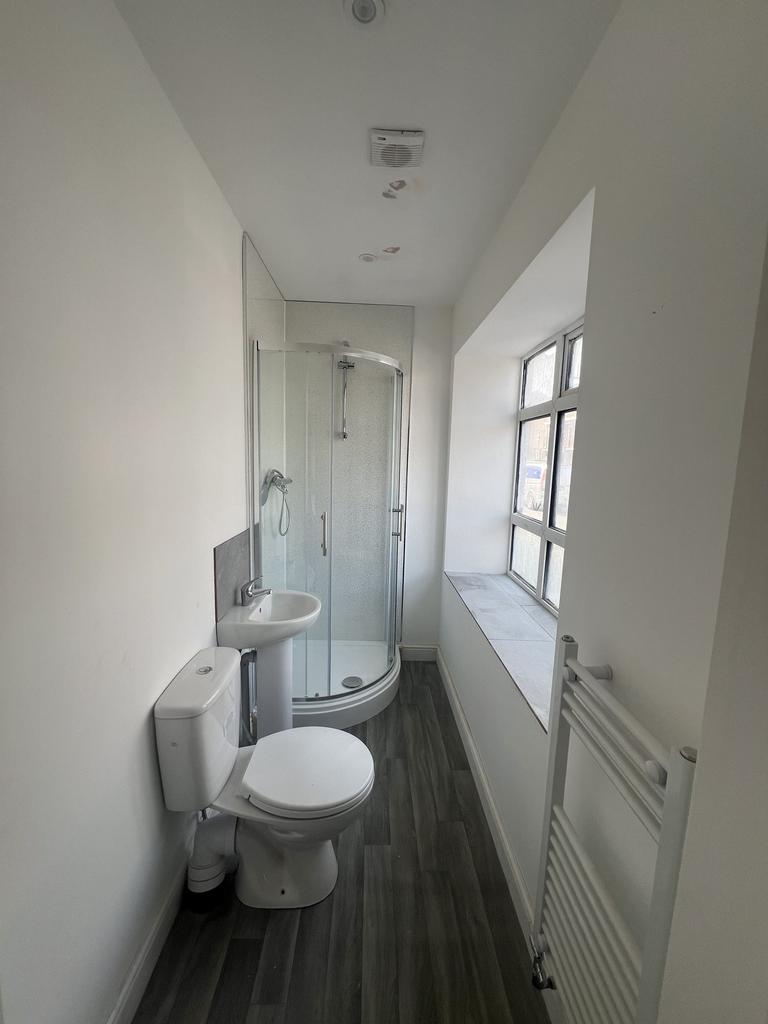 Bright, modern bathroom with a corner shower en...