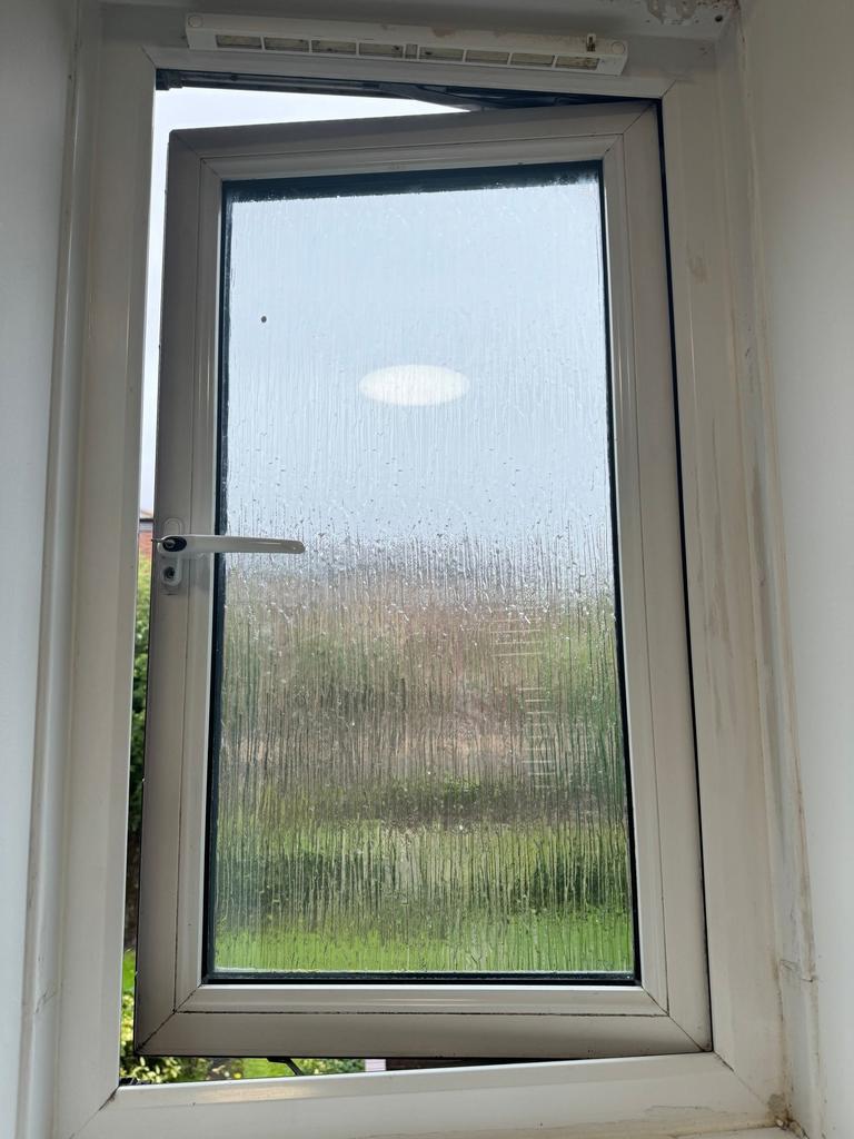 Compact frosted casement window with a white u P...